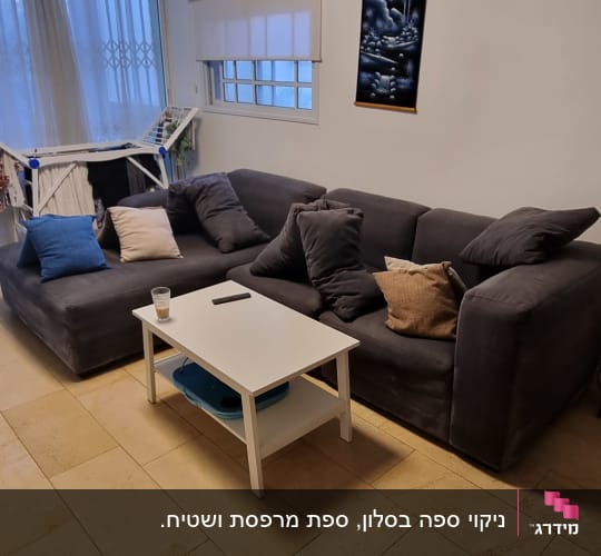 ספה אפורה עם כריות ושולחן לבן בסלון